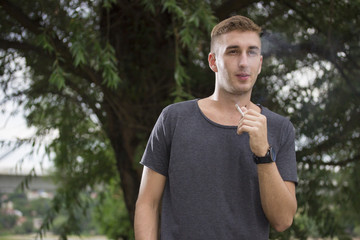 Naklejka na ściany i meble close up of young male hipster smoking cigarette
