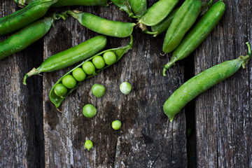 Young fresh green peas on wooden background