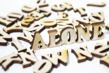 "Alone" written in wooden letters