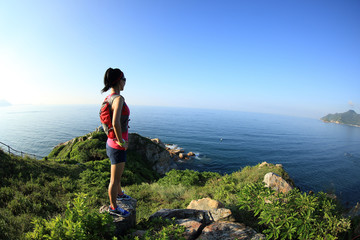  young fitness woman trail runner/ hiker on seaside mountain peak