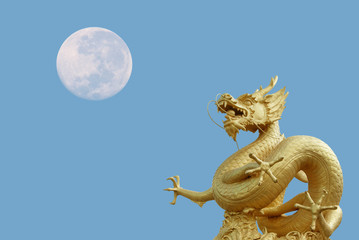 Fototapeta premium golden dragon statue and moon at isolated on blue sky background