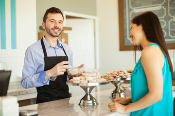 Young man working in a cake shop
