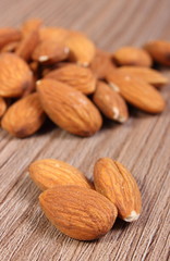 Heap of almonds on wooden background