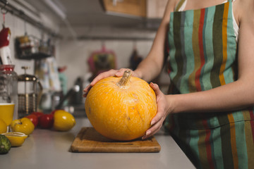 Obraz na płótnie Canvas Woman's hands holding a pumpkin
