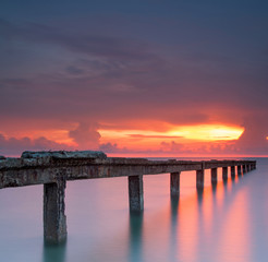 Beautiful sunrise at the sea with stone bridge