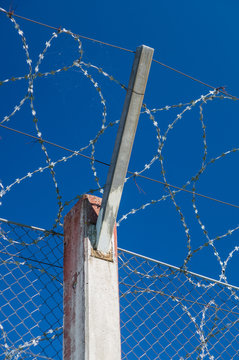 Prison concrete pillar and barbed wire fence