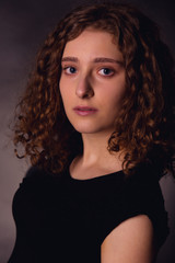 Fototapeta premium Portrait of red-haired young woman in a low key