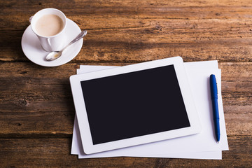 digital tablet and coffee on old wooden background
