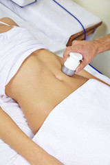 Naklejka premium Frau bekommt Elektromassage am Bauch