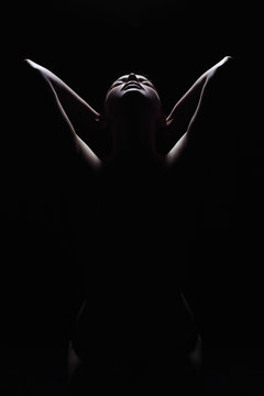 dark female silhouette,hands and face.art photo of nude body girl