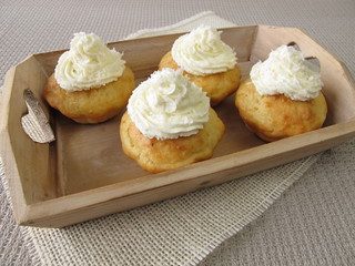 Coconut cupcakes with whipped cream on tray