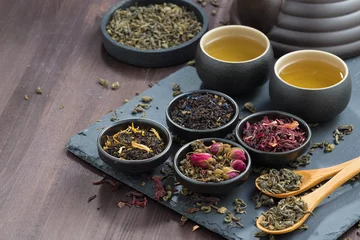 Papier Peint photo autocollant Theé assortiment de thés séchés parfumés et de thé vert sur table en bois