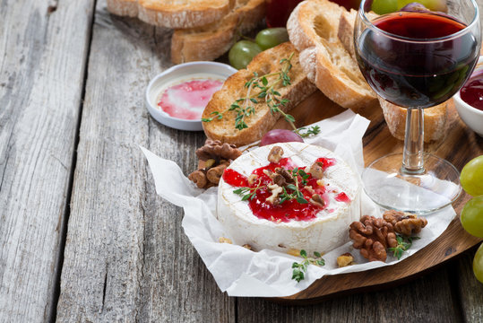 delicious appetizers - camembert with berry jam, toast and grape