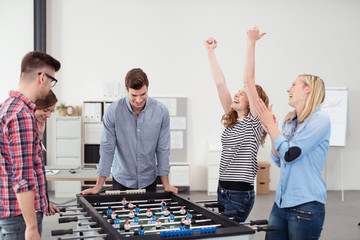 team gewinnt beim kicker im büro - obrazy, fototapety, plakaty