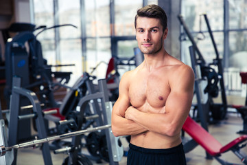 Man standing with arms folded at gym
