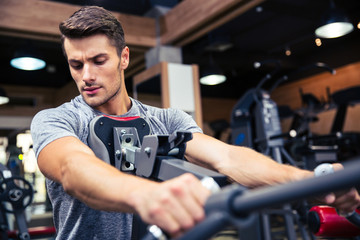 Fototapeta na wymiar Man workout on fitness machine at gym