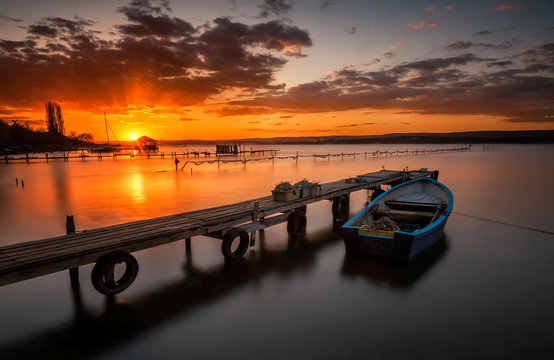Lonely boat at sunset. Magnificent long exposure lake sunset near Varna, Bulgaria