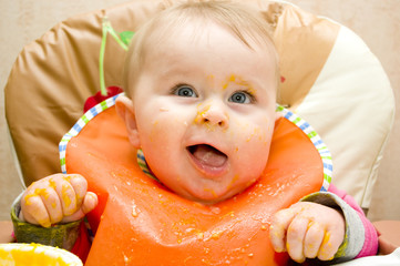 Funny infant boy with stained face, clothes and arms after his first self-eating - 90984904