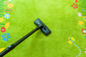 Vacuum cleaner cleans carpet, with copy space for text message, advertising - Spring Cleaning Concept 