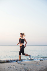 Running woman. Female runner jogging during the sunrise on beach.