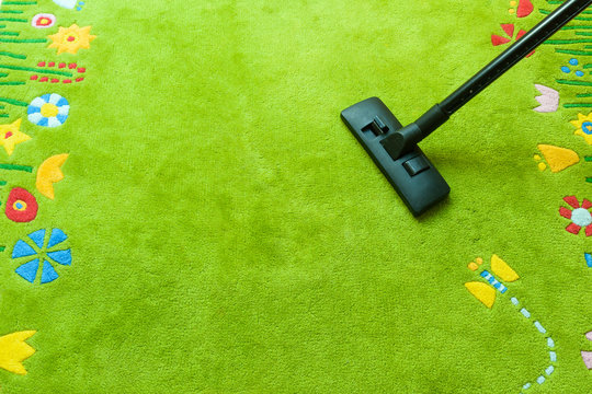 Vacuum cleaner cleans carpet, with copy space for text message, advertising - Spring Cleaning Concept 