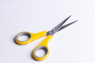 Yellow and grey scissors on white background