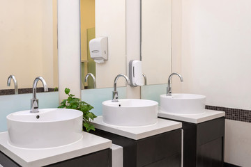 Fototapeta na wymiar white basins in bathroom interior with granitic tiles