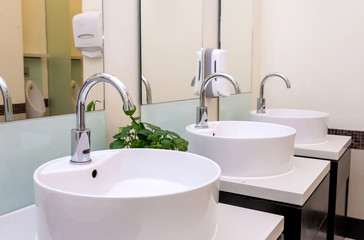 white basins in bathroom interior with granitic tiles