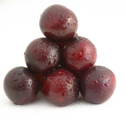 Isolated cherries lie on each other in a pyramid. Water drops on the berries
