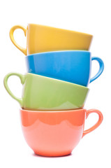 Four cups stacked. Colored mugs. Colorful image with tableware.