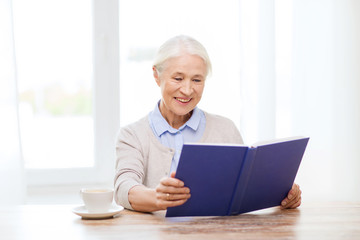 happy smiling senior woman reading book at home