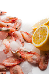 Frozen shrimps and lemons on the white background vertical