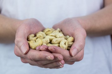 Woman showing handful of cashews