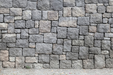 Naklejka premium Gray stone wall and road, background texture