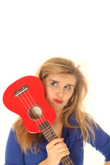 Fototapeta premium Blond woman holding a ukulele to her face