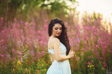 Beautiful young woman in purple flowers outdoors