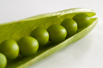 Close up of fresh green peas in open pod.
