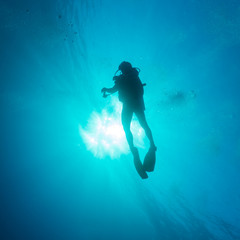 Silhouette of diver with sun disk