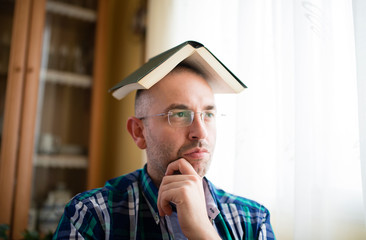 Adult man with a book on his head