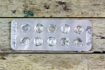 empty pills in package wood background, isolated