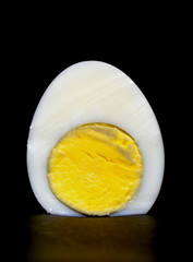 sliced boiled egg with the yolk purified on a black background