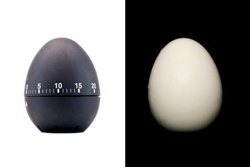 Timer as a black egg isolated on white background and boiled peeled egg on a black background