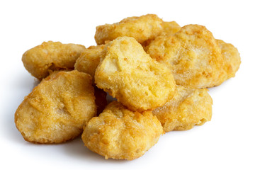 Pile of frozen battered chicken nuggets uncooked and isolated on
