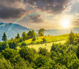 fence on hillside meadow in mountain at sunset