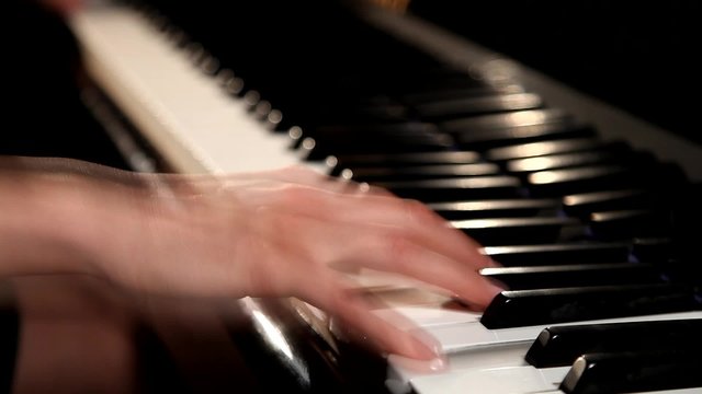 Two hands playing  on a beautiful grand piano.