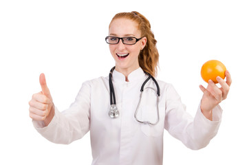 Pretty female doctor with stethoscope and orange isolated on whi