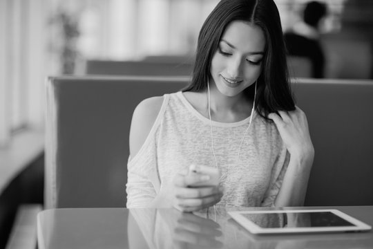 beautiful young girl enjoys phone and tablet