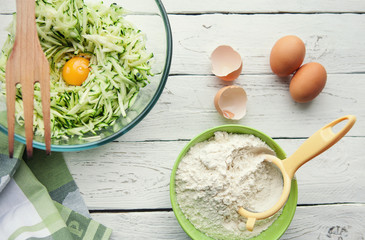 Table with ingredients for cooking zucchini pancakes