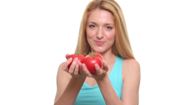 Young slim woman is holding three red juicy tomatoes