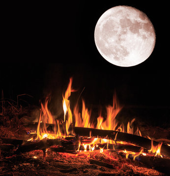 camp fire and big moon at night